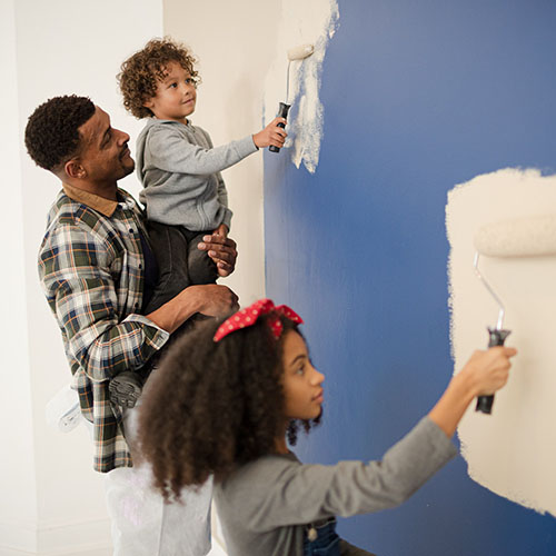 happy family painting a wall in their home together